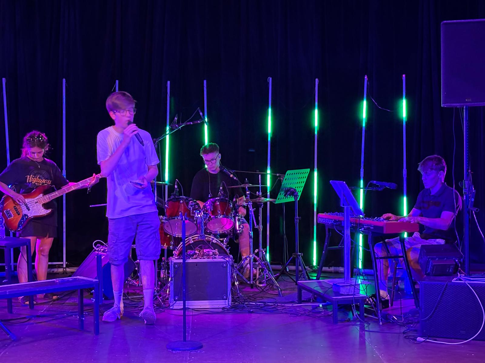Full band on stage at Circus Paletti, purple and green stage lighting
